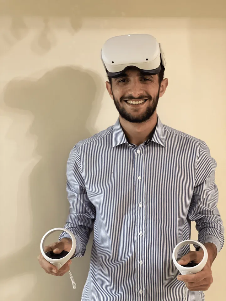 Monier Hossam, senior Unity developer, holding a Meta Quest VR headset and controllers
